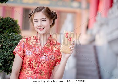 The Asian Woman In Chinese Dress Holding Couplet 'happy.' (chinese Blessing Word) With Chinese Templ