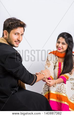Indian young sister tying rakhi on brother's wrist, a tradition on Raksha Bandhan festival