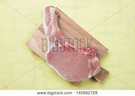 Raw porkchop on wooden broad / cooking porkchop steak concept