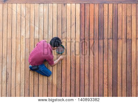 A Man Painting Exterior Wooden Pool Deck, Top View