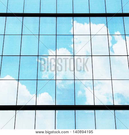windows of modern skyscraper building with sky reflection
