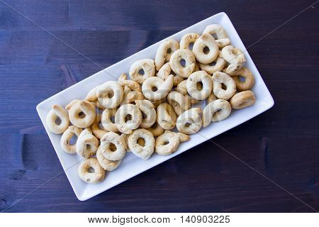 Bagels on a ceramic tray on a wooden table seen from above