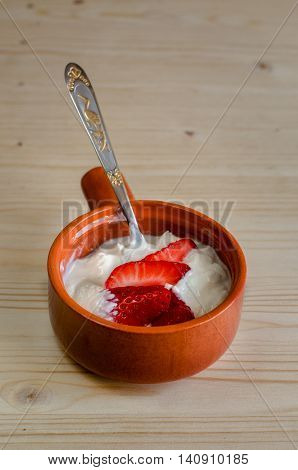 Cottage cheese with strawberries in a ceramic bowl