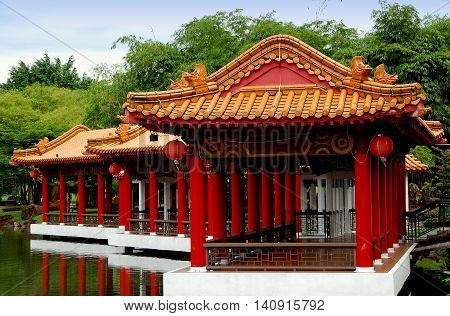 Singapore - December 27 2007: Lakeside viewing pavilions with orange tiled roofs and carved animal figures on the lagoon at the classical Chinese Garden