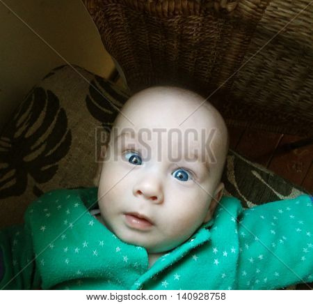 Silly face of small baby with blue eyes. Stupid but cute