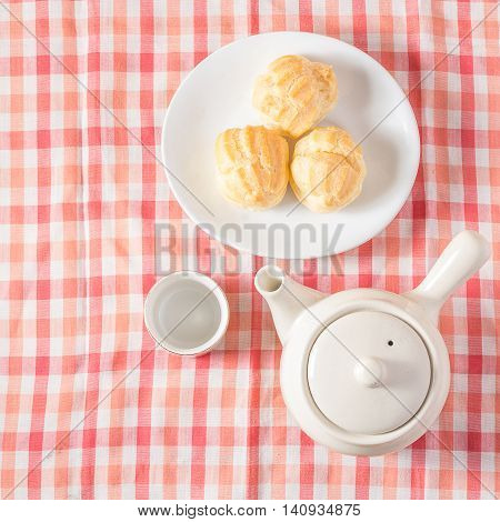 Eclair cream dessert in a dish on red and white chintz background.