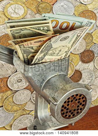 Money and business concept.Dollar banknotes in meat grinder on lot of different coins background.
