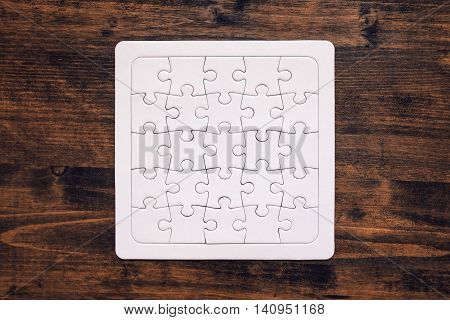 Completed jigsaw puzzle as copy space placed on wooden desk top view