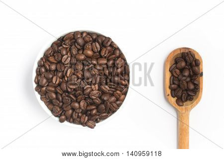 Coffee beans into a bowl and spoon on white background. Coffea arabica