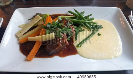 Veal Cheek with Garlic Puree and Vegetables in a French Restaurant
