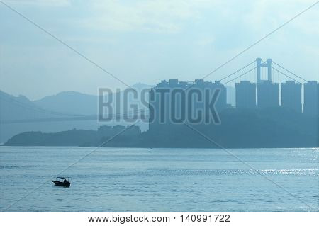 hong kong sky line over habor bridge in background junk dingy boat
