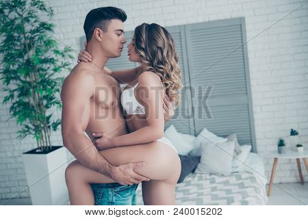 Side View Profile Of Stunning Muscular Man With Torso In Jeans Holding His Sexy, Young Woman With Pe