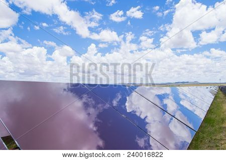 Greem Energy Produced By Solar Panels On A Sunny Day With White Clouds And Blue Sky