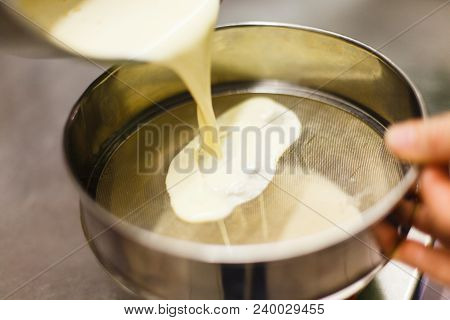 The Process Of Straining When Preparing The Brule Cream. Vanilla Pods On A Steel Sieve. Professional