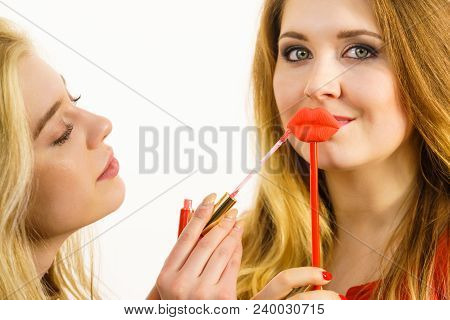Young Adult Woman Applying Lipstick Or Lip Gloss, Getting Her Make Up Done Holding Fake Lips On Stic