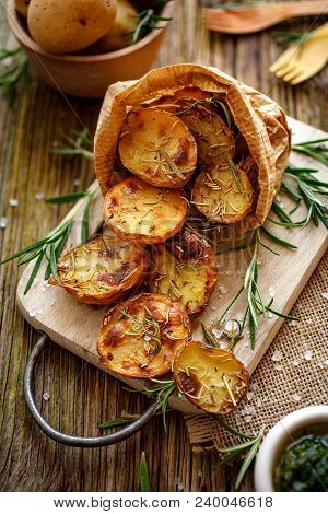 Baked Potatoes. Baked Halves Of Potatoes Seasoned With Rosemary And Sea Salt On A Wooden Rustic Tabl