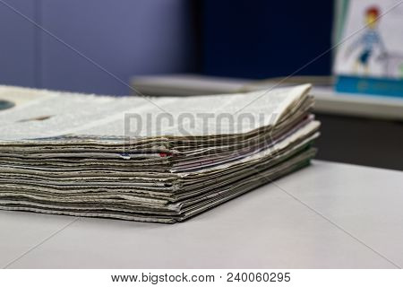 Closeup - Newspaper Stack On White Table In Office