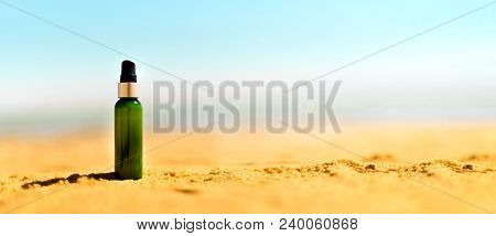Bottle Of Sunscreen In Sand Against Sea Background With Copyspace. Vacation And Travel Wallpaper. Sk