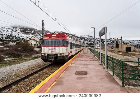 Otero De Herreros, Spain - March 31, 2018: Train Entering The Station Against Snowcapped Mountains