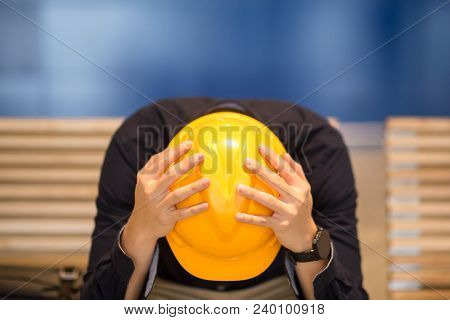 Young Asian Engineer Or Architect Man Feeling Tried And Worried While Sitting On Bench Holding His P