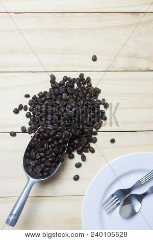Coffee Beans In Scoop On Wood Background