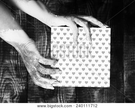 Female Hands Smeared In Golden Paint Or Glister Holding Pink Polka Dots Valentine Present Box On Bro