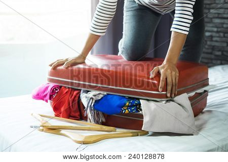 Travel And Vacation Concept, Happiness Young Woman Packing A Lot Of Her Clothes And Stuff Into Suitc