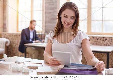 Appropriate Color. Inspired Female Designer Using Tablet While Touching Fabric