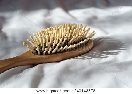 Hair Fall, Hair Loss Problem. Wooden Brown Comb With Hair Loss On White Bed Cover. Woman Healthy And