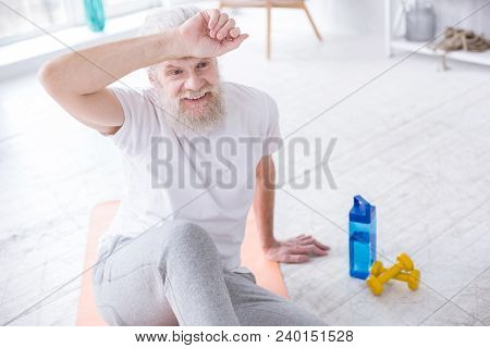 Regaining Energy. The Top View Of A Handsome Elderly Man Relaxing After Workout And Wiping Off The S