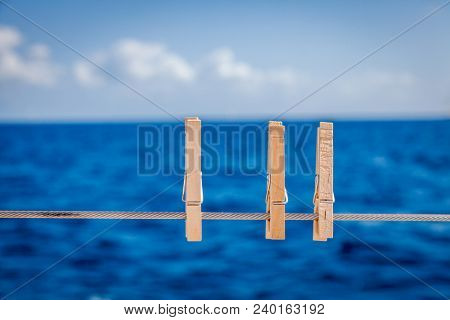 Cllose-up image of wooden cloth pins on a sailboat railing