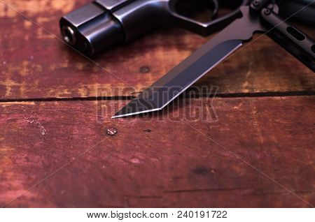 Blade Of A Knife And A Muzzle Of A Pistol.
