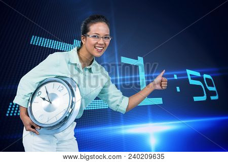 Happy business woman holding a clock against background with clock