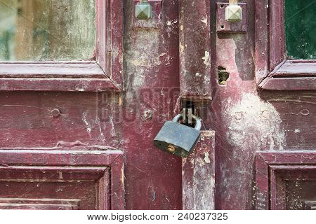 Fragment Of An Old Wooden Door Closed On A Padlock