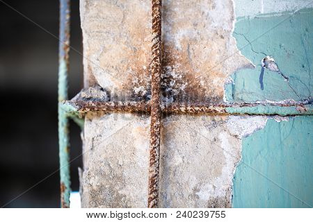 Part Of Cratched And Broken Down Painted Cement Wall With Rusty Reinforcement And Old Color Ragged P