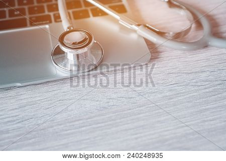 Stethoscope On Laptop Computer At Medicine Doctor Work Office In Hospital Or Clinic With Light Flare