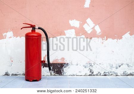 Old And Rusty Fire Extinguisher On The Ground With A Copy Space.