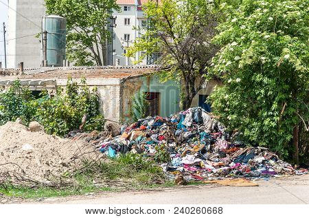 Abandoned Rural Damaged House In The Ghetto Near New Residential Building In The City Used As Garbag