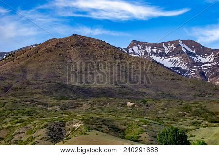 Beautiful Landscape Of Snow On The Mountains With A Clear Sky And Some Clouds And Foothills In The F