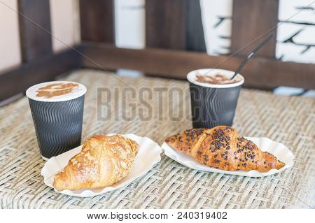 Cappuccino With Croissant. Two Cups Of Coffee With Milk Foam Stands On A Table In Cafeteria. Two Cup