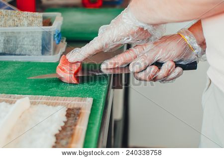 Professional Chef, Chef The Process Of Making Sushi Rolls, Spins Bamboo Mat And Cut Slices
