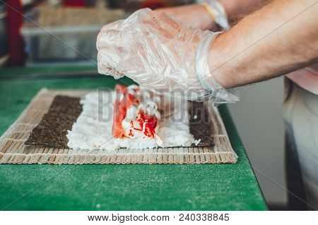 Professional Chef, Chef The Process Of Making Sushi Rolls, Spins Bamboo Mat And Cut Slices