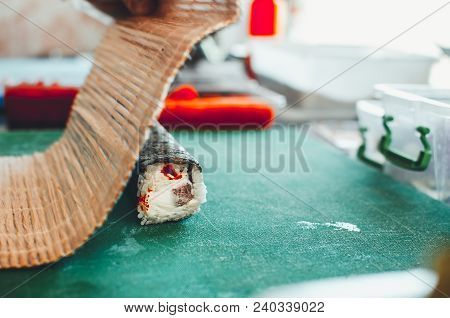 Professional Chef, Chef The Process Of Making Sushi Rolls, Spins Bamboo Mat And Cut Slices