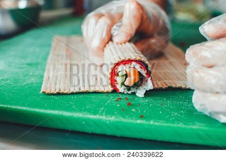 Professional Chef, Chef The Process Of Making Sushi Rolls, Spins Bamboo Mat And Cut Slices