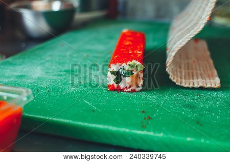 Professional Chef, Chef The Process Of Making Sushi Rolls, Spins Bamboo Mat And Cut Slices