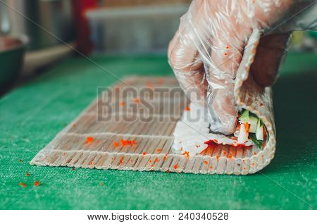 Professional Chef, Chef The Process Of Making Sushi Rolls, Spins Bamboo Mat And Cut Slices