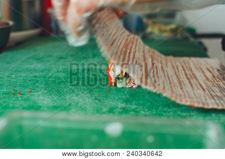 Professional Chef, Chef The Process Of Making Sushi Rolls, Spins Bamboo Mat And Cut Slices