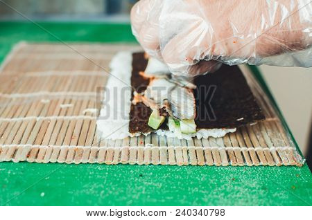 Professional Chef, Chef The Process Of Making Sushi Rolls, Spins Bamboo Mat And Cut Slices