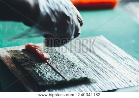 Professional Chef, Chef The Process Of Making Sushi Rolls, Spins Bamboo Mat And Cut Slices