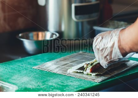 Professional Chef, Chef The Process Of Making Sushi Rolls, Spins Bamboo Mat And Cut Slices